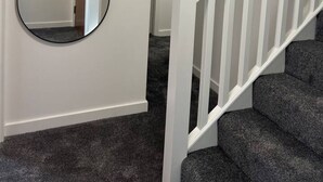 A staircase with white railings and a carpeted floor leading to a door. - Ensuite Double Room Near Clapham (London)
