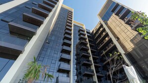 Un edificio moderno de gran altura con múltiples balcones y un diseño arquitectónico actual.