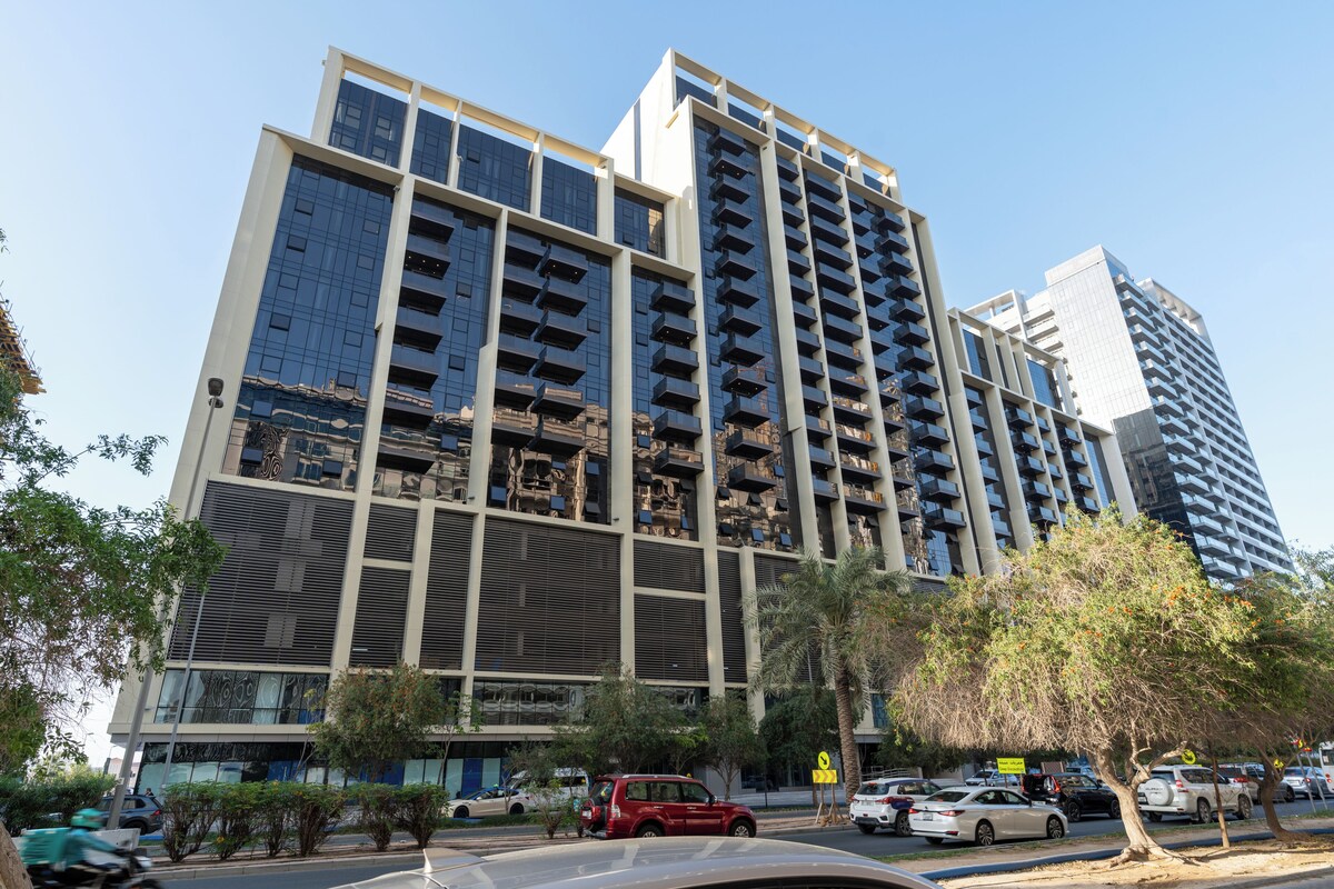 A multi-story building with a modern architectural design, featuring balconies and large windows.