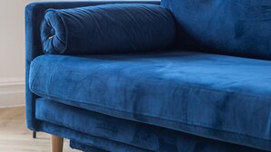 A blue sofa with wooden legs in a room with light-colored walls and wooden flooring. - Modern Brixton Flat 3 (Magherafelt)