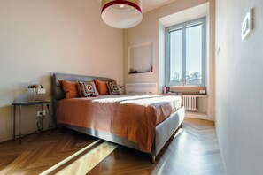 Ein modernes Schlafzimmer mit Bett, Nachttisch, Lampe und Fenster mit Blick.
