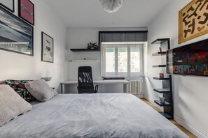 A bedroom with a bed, a desk, a chair, and a radiator. - Double Room Private Bathroom (Rome)