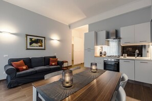 A modern kitchen with white cabinets, a built-in oven, and a gas stove. - 2-bedroom Roman Gem in Rome (Rome)