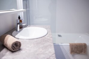 A bathroom with a white sink, a towel, and a glass shower enclosure. - Bel Appartement r nov - Centre Ville d Annecy (Annecy)