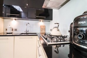 Eine moderne Küche mit Gasherd, Spüle und integriertem Backofen.