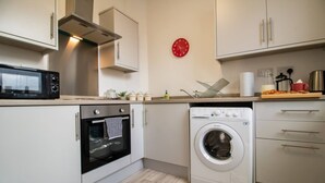 Cocina compacta con microondas, horno y lavadora.