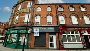 A multi-story building with a ground floor featuring a shop named 'Knights' and another named 'Forces Careers.' - 1BR Urban Retreat in Central Sunderland (Sunderland)