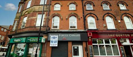 A multi-story building with a ground floor featuring a shop named 'Knights' and another named 'Forces Careers.'