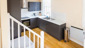 A modern kitchen with a built-in oven, a sink, and a window. - Charlotte House Prime Location Urban Nest 2bed 2bath (Ipswich)