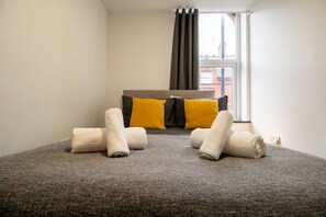 A hotel room with a bed, pillows, and rolled towels. - Homey 1-bed Apartment in the Heart of Sunderland (Sunderland)