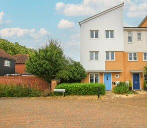 Un immeuble résidentiel à plusieurs étages, doté d’une façade en briques, d’une porte bleue et d’une enseigne indiquant « Lambeth Road ».