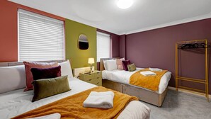 A hotel room with two beds, a mirror, a coat rack, and a window with blinds. - Harland Haven Spacious 4BR House in Ipswich (Ipswich)