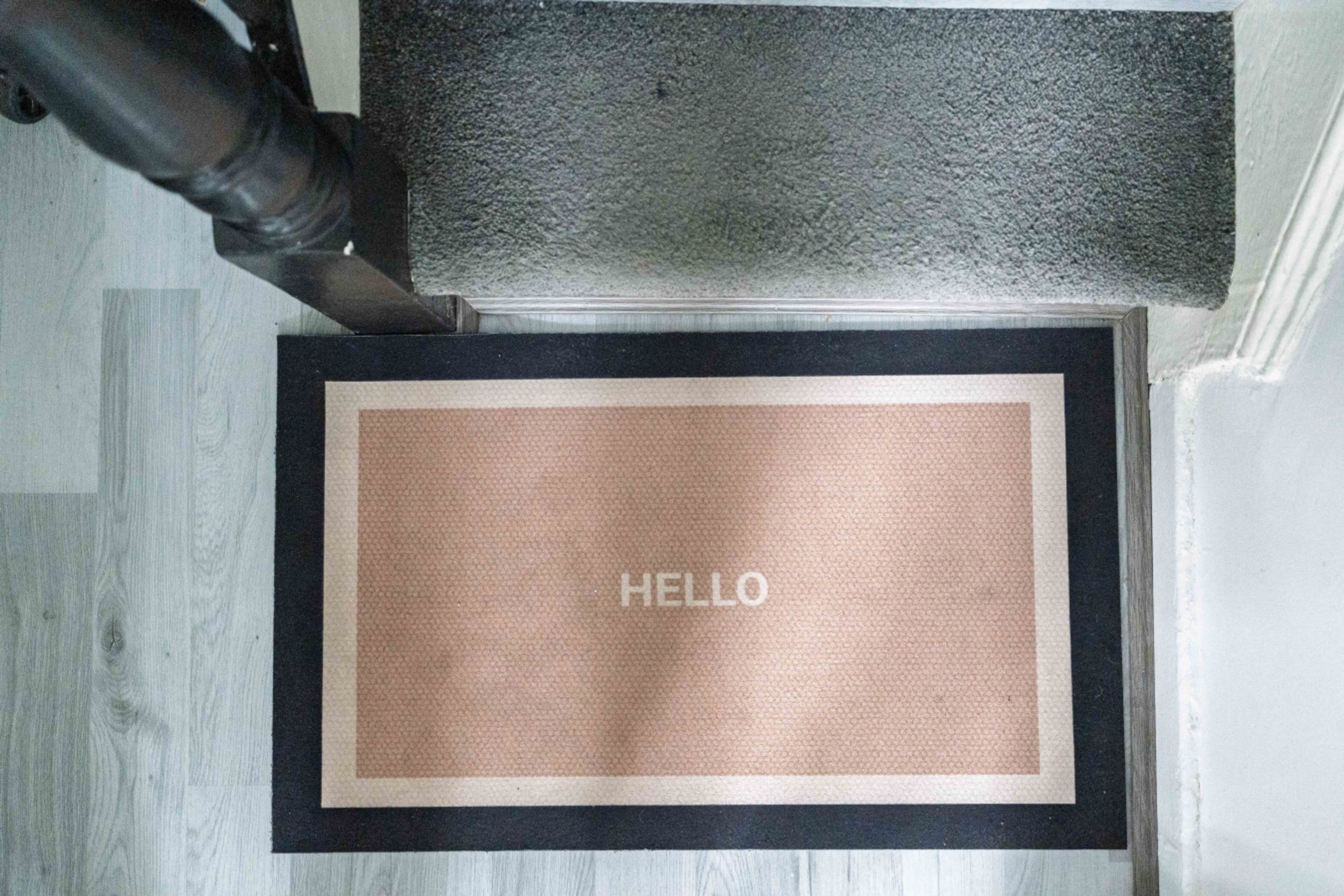 Un paillasson avec le mot « HELLO » inscrit sur une surface texturée.