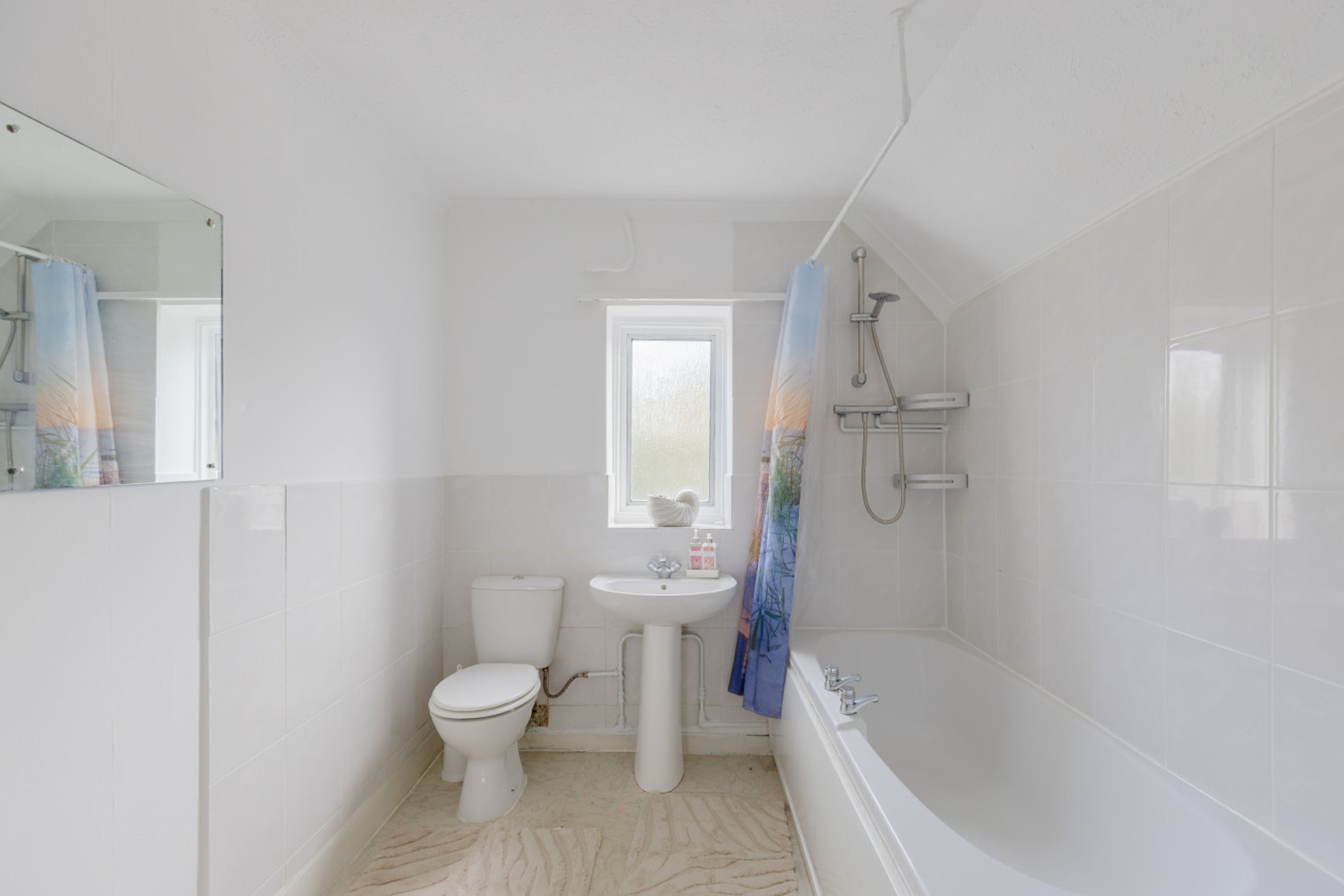 A bathroom with a toilet, sink, and bathtub.
