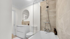 Ein modernes Badezimmer mit Badewanne, Toilette und Waschbecken.
