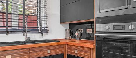 A kitchen with a built-in oven, a microwave, and a coffee maker.