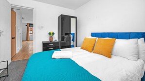A bedroom with a bed, a wardrobe, a nightstand, and a mirror. - Cozy 1-bed Flat in Croydon Sleeps 4 - Free Parking (Croydon)
