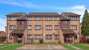 A two-story apartment building with a brick facade, multiple windows, and a parking area in front. - Cozy 1-bed Flat in Croydon Sleeps 4 - Free Parking (Croydon)
