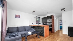 A modern living space with a sofa, coffee table, and kitchen area. - Cozy 1-bed Flat in Croydon Sleeps 4 - Free Parking (Croydon)