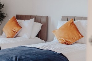 A bedroom with two beds, each with a headboard and multiple pillows. - Elizabeth Line Retreat Modern 2BR Flat in Hayes (Hayes)