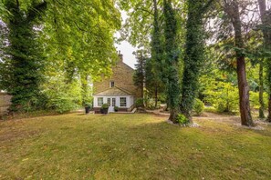 Ein Haus mit Garten, umgeben von Bäumen.