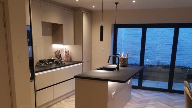 A modern kitchen with a central island, built-in cabinets, and a large window offering a view. - London 2BR Retreat With Free Parking City Access (London)