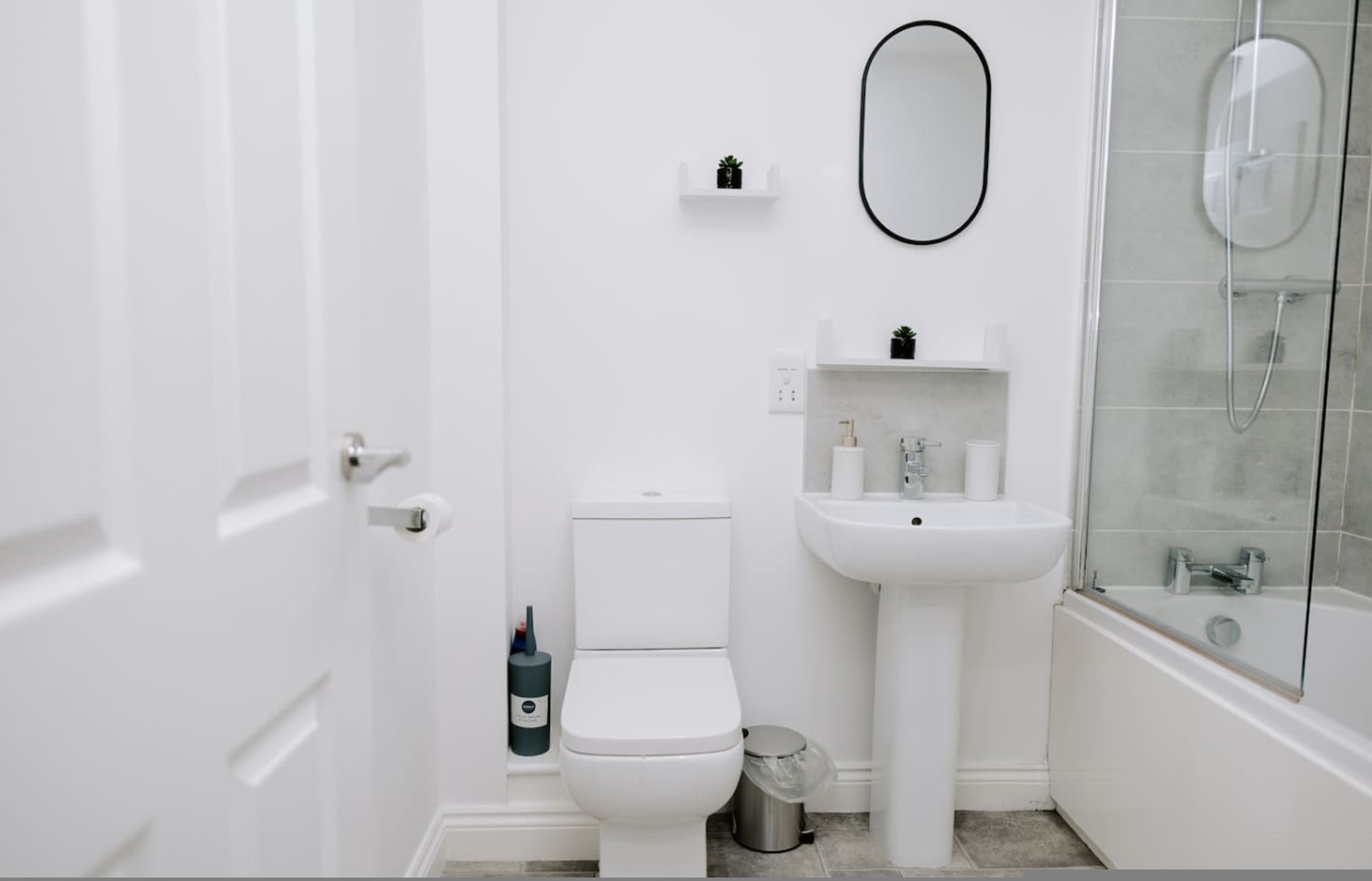 A bathroom with a toilet, sink, and shower.