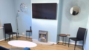 A living room with a TV, fireplace, and seating area. - West Midlands Home - 3BR w Free Parking and Wifi (Dudley)