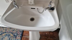 A white sink with two faucets, a soap dispenser, and a drain. - Stylish East London Retreat With Private Terrace Fast Wifi (London)