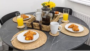 Een ontbijt met croissants, koffie en sinaasappelsap op een marmeren tafel.