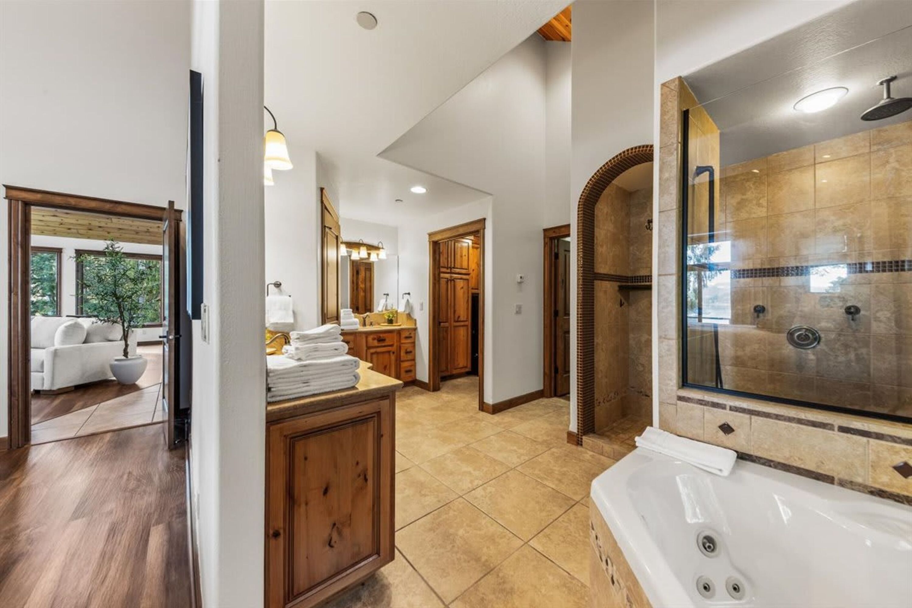 Un baño moderno con ducha de vidrio, bañera y muebles de madera.