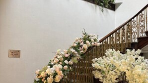 Una escalera con barandillas de metal ornamentadas y detalles florales.