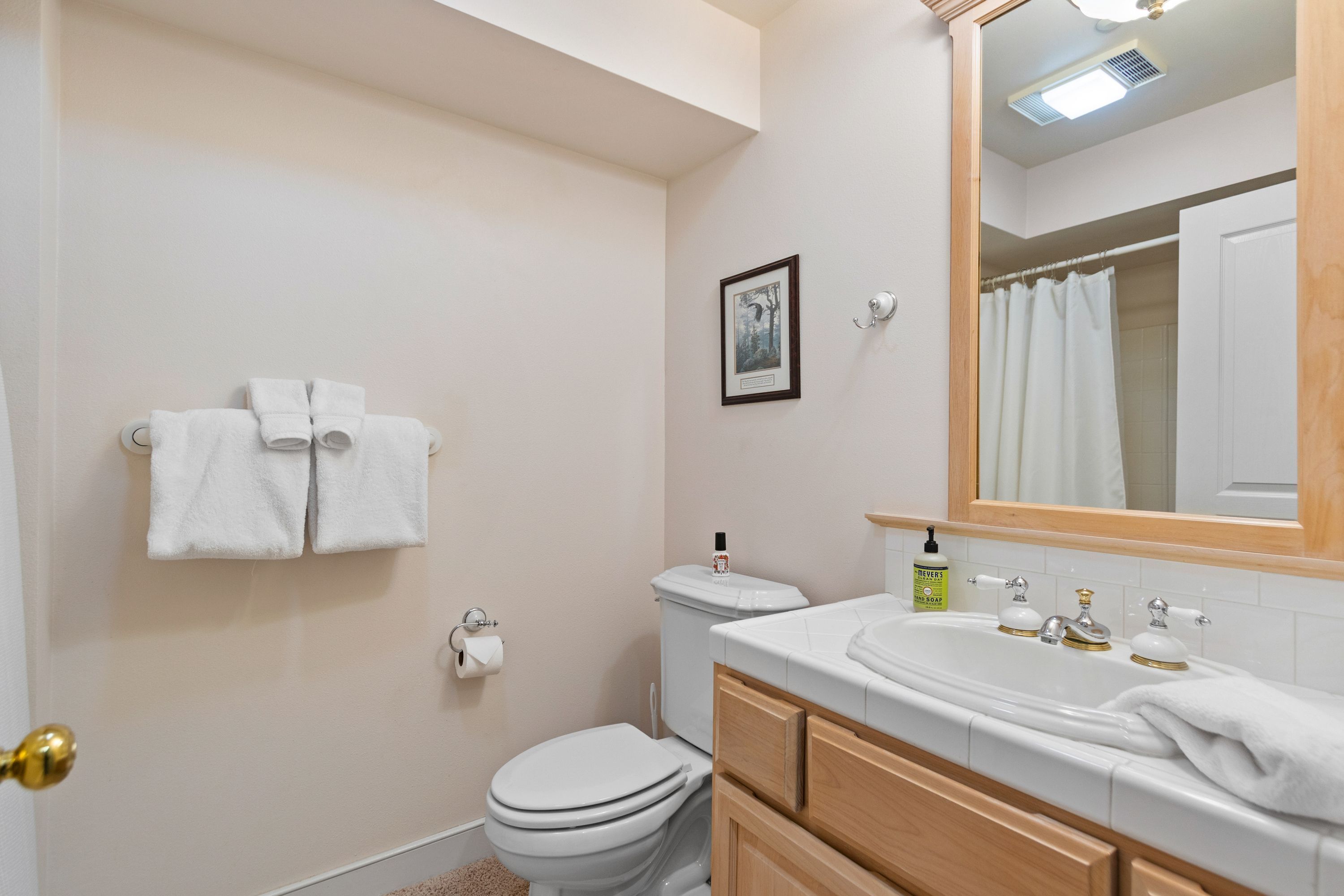 A bathroom with a toilet, sink, and towel rack.
