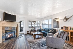 Una sala de estar con chimenea, televisor, sofá, mesa de centro y estantería.