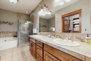A modern bathroom with a double sink, a glass shower enclosure, and a large mirror. - Fabulous Riverstone Retreat (Coeur d'Alene)