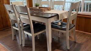 A dining table with six chairs, a woven placemat, and a small potted plant. - Lakeside Cabin in Hayden (Hayden)
