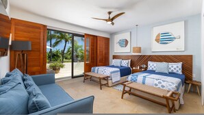 Ein Hotelzimmer mit Bett, Sofa, Deckenventilator und Blick auf Palmen.