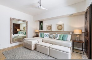 A modern bedroom with a large bed, a sofa, a patterned rug, and a ceiling fan. - Casa Sole in Punta Mita (Punta de Mita)