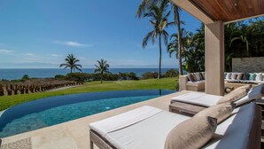 A infinity pool with lounge chairs, a wooden pergola, and a view of the ocean. - Casa Sole in Punta Mita (Punta de Mita)