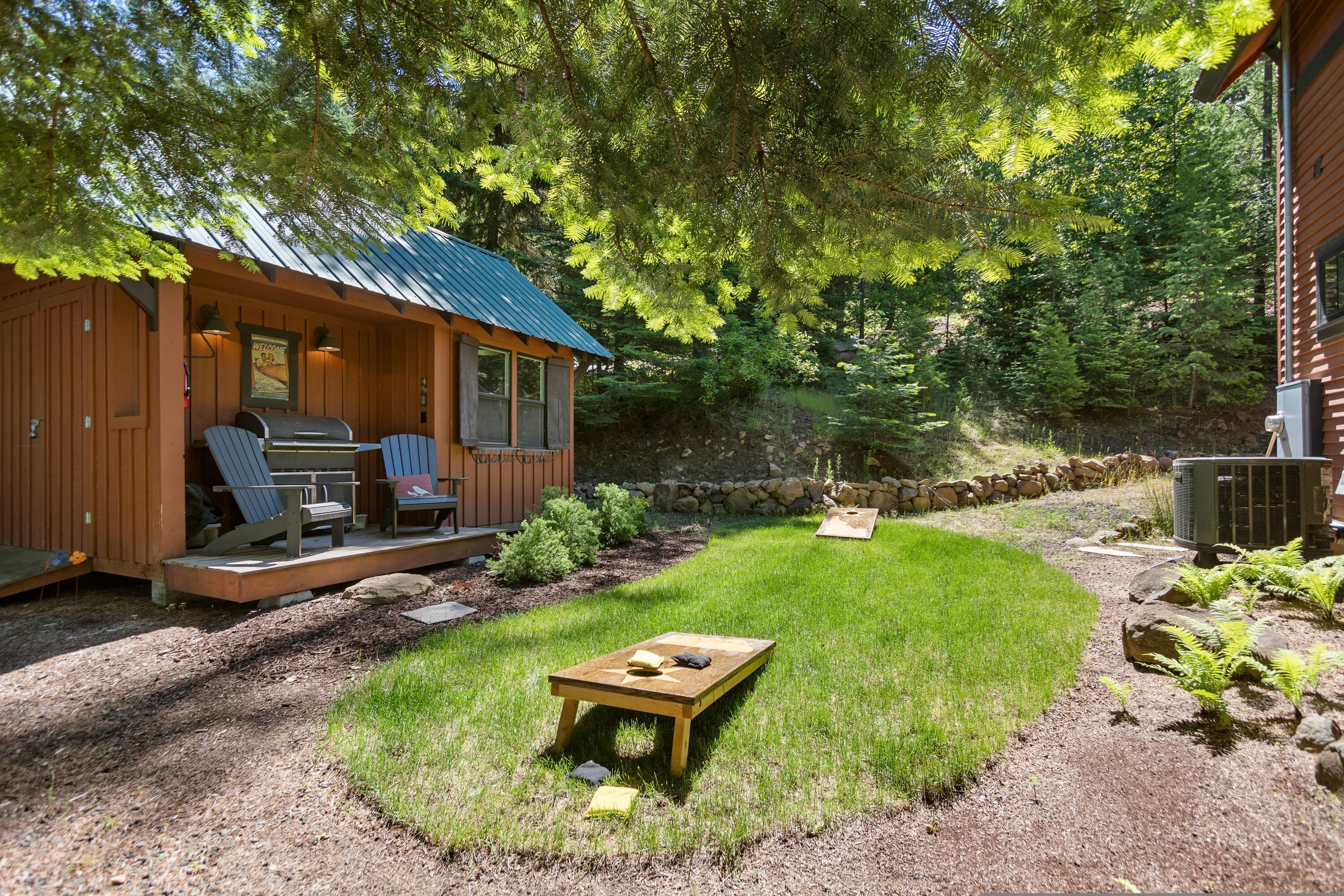 Eine Hütte mit Veranda, Sitzgelegenheiten im Freien und einem kleinen Tisch.