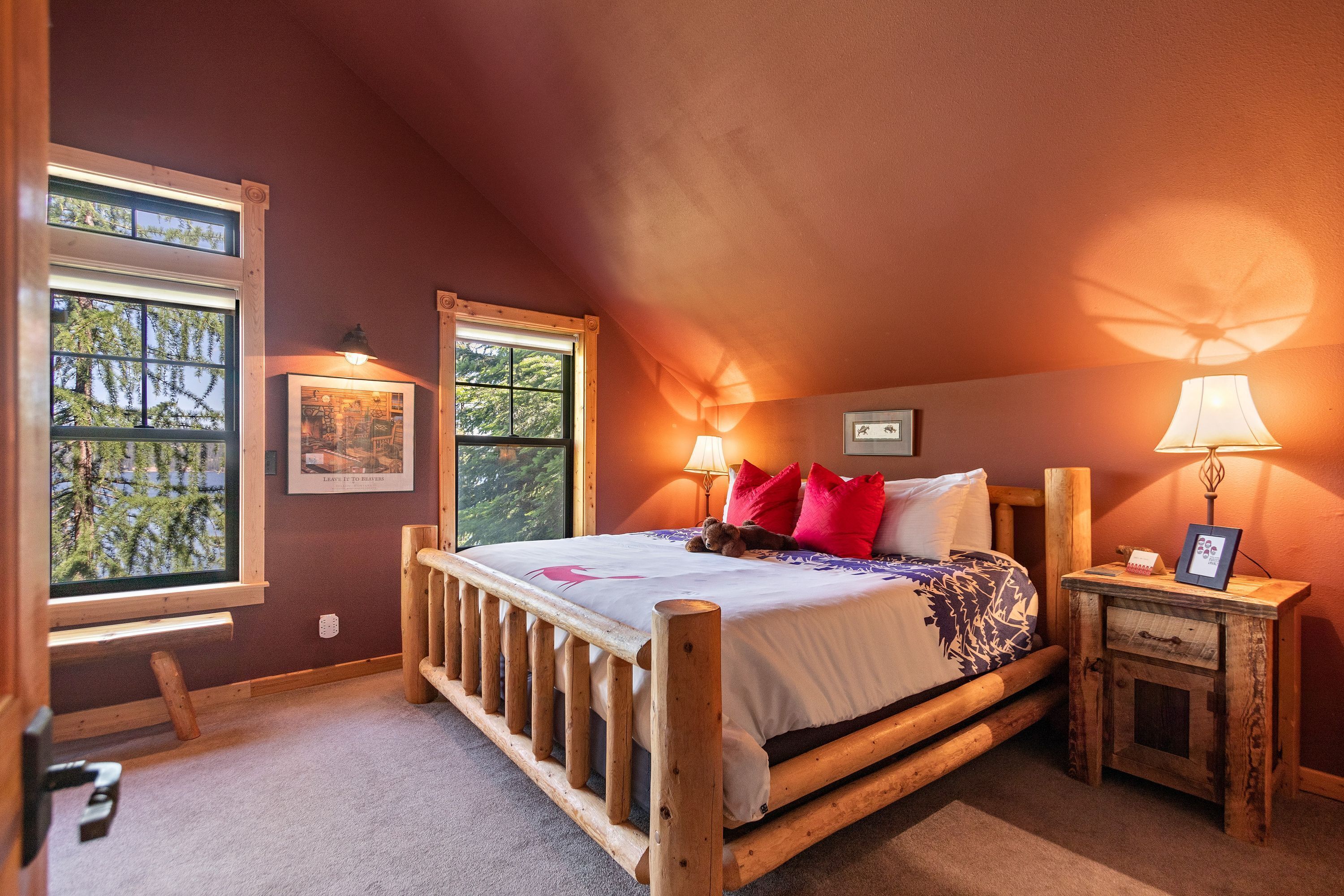 Een slaapkamer met een houten bed, twee nachtkastjes, een raam en een deur.