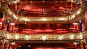 Ein Theater mit aufwendiger Architektur, mehreren Balkonen und roten Sitzplätzen.