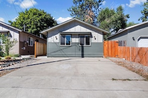 A single-story house with a front garage, a wooden fence, and a clear driveway. - Coeur d Alene Charm in Coeur d Alene (Coeur d'Alene)