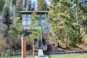 A two-story cabin with a dock extending into a river, surrounded by dense forest. - Starling Lake House in Hayden (Hayden)