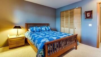 A bedroom with a wooden bed, a nightstand, a lamp, and a wardrobe.
