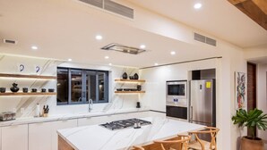 Una cocina moderna con una isla central, electrodomésticos integrados y una ventana con vistas al interior.
