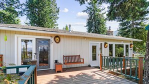 A wooden deck with a bench, a small table, and a porch railing.