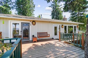 A wooden deck with a bench, a small table, and a porch railing.