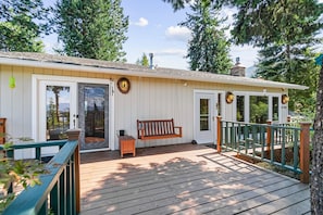 A wooden deck with a bench, a small table, and a porch railing. - Lake View Getaway in Hayden (Hayden)