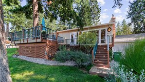 A two-story house with a deck, a staircase, and a mailbox.
